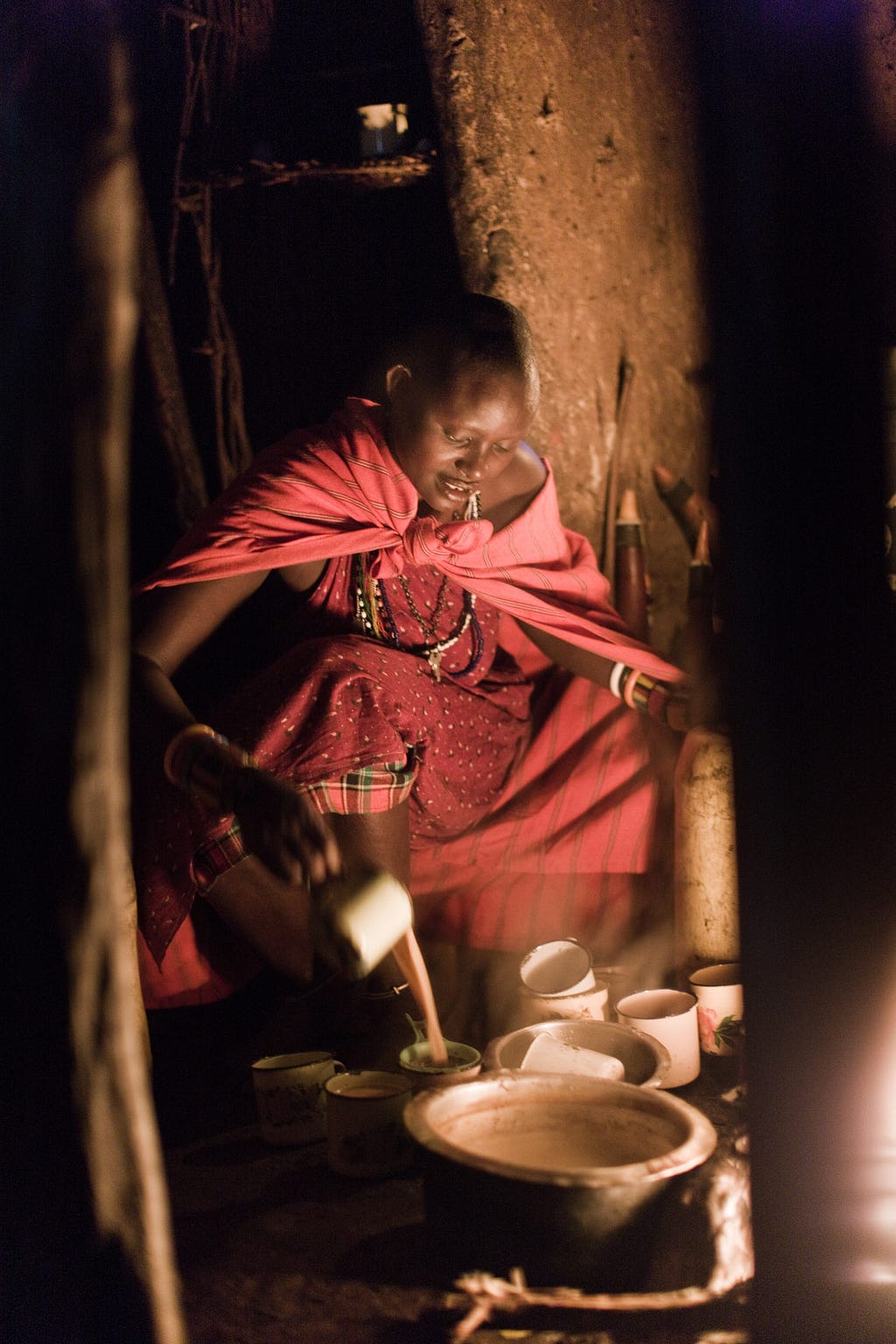 A Maasai woman makes morning tea with milk still warm from one of the village cows.