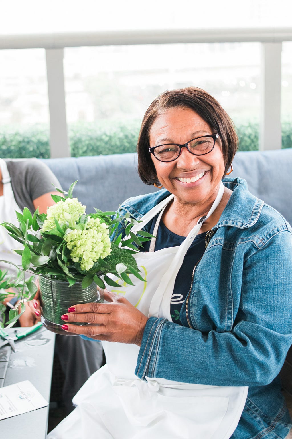 women smiling with her floral arrangement during Alice's Table workshop in Jacksonville, Florida