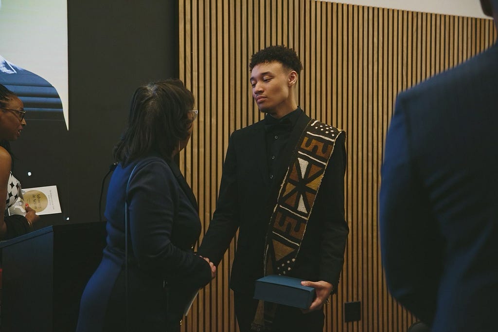 Cayden Brown stuns in an African-inspired mudcloth draped over his shoulder as he receives the ‘Youth Justice Advocate Award’