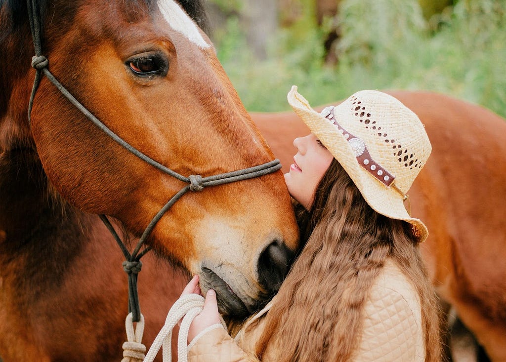 A woman cuddling a horse