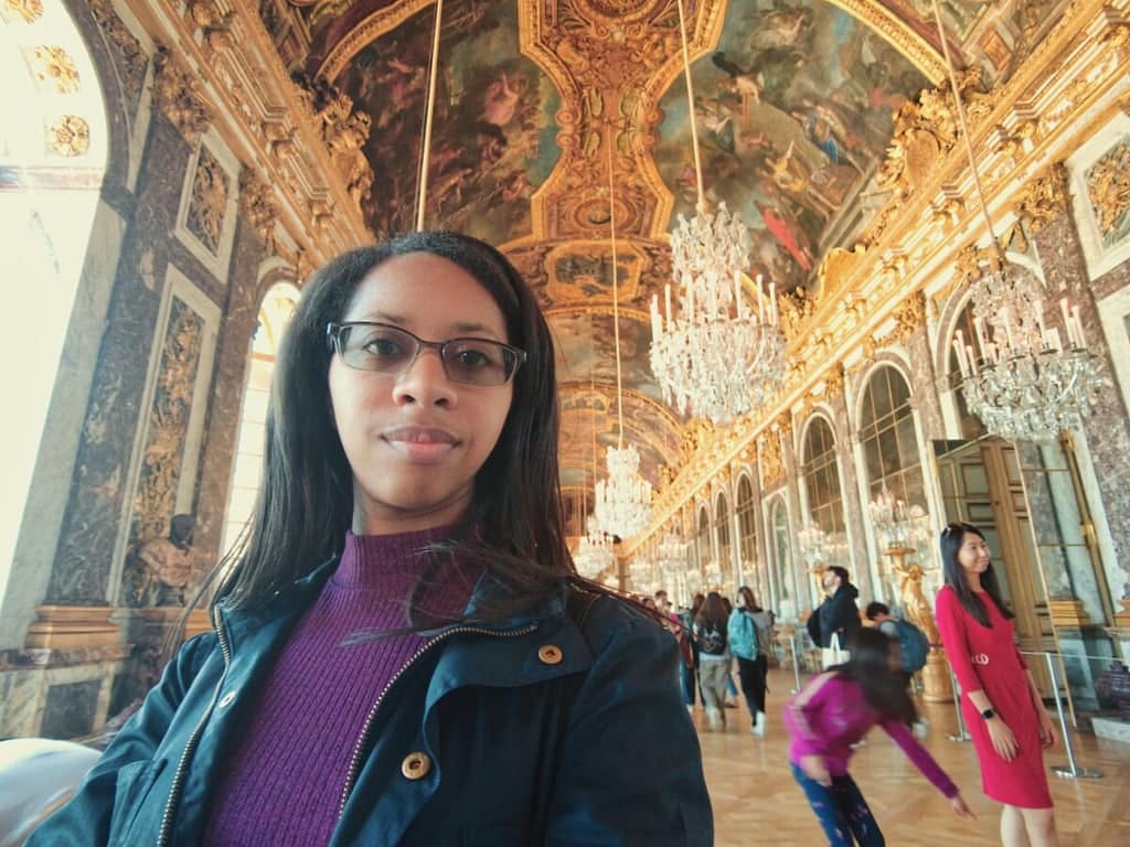 A woman is taking a selfie in an ornate room.