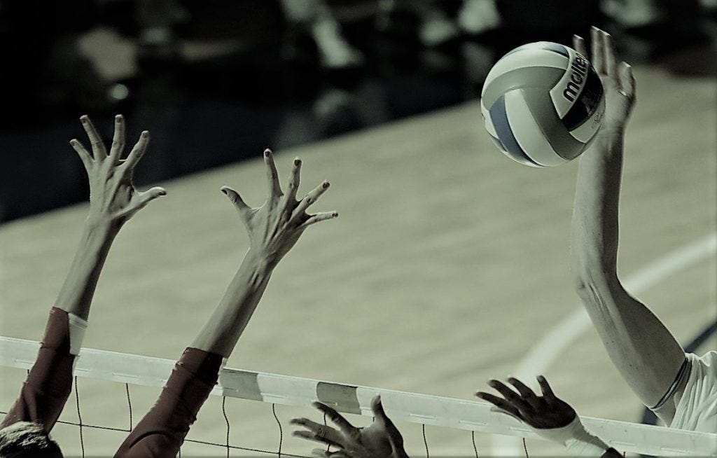Gitl volleyball player spking a ball