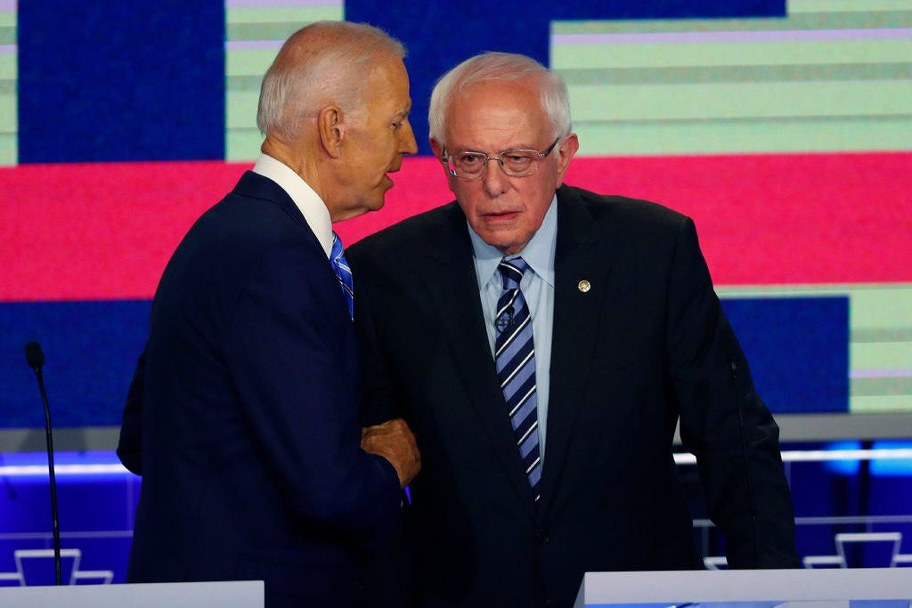 Joe Biden and Bernie Sanders shake hands.