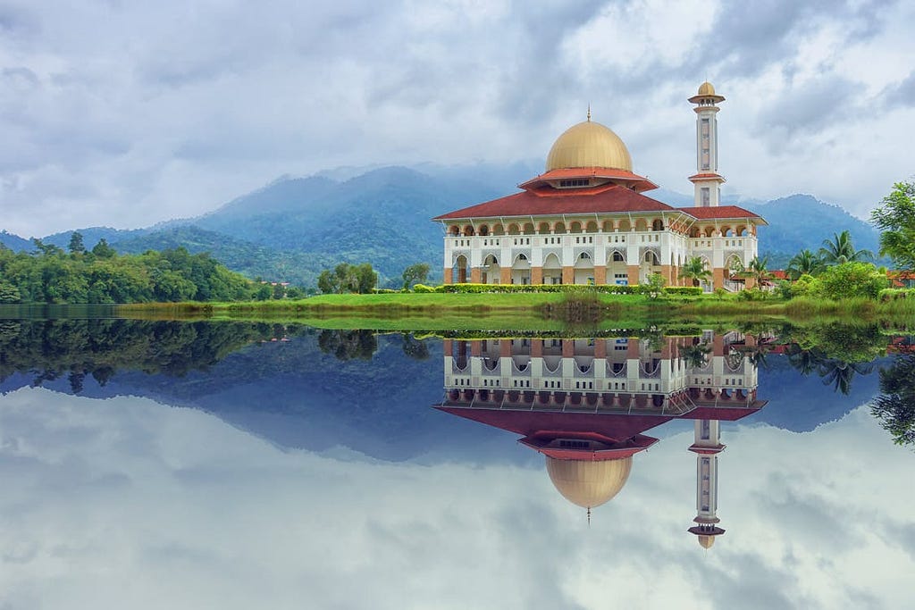 White and Red House Reflecting on Body of Water Under Blue Sky, Malaysia