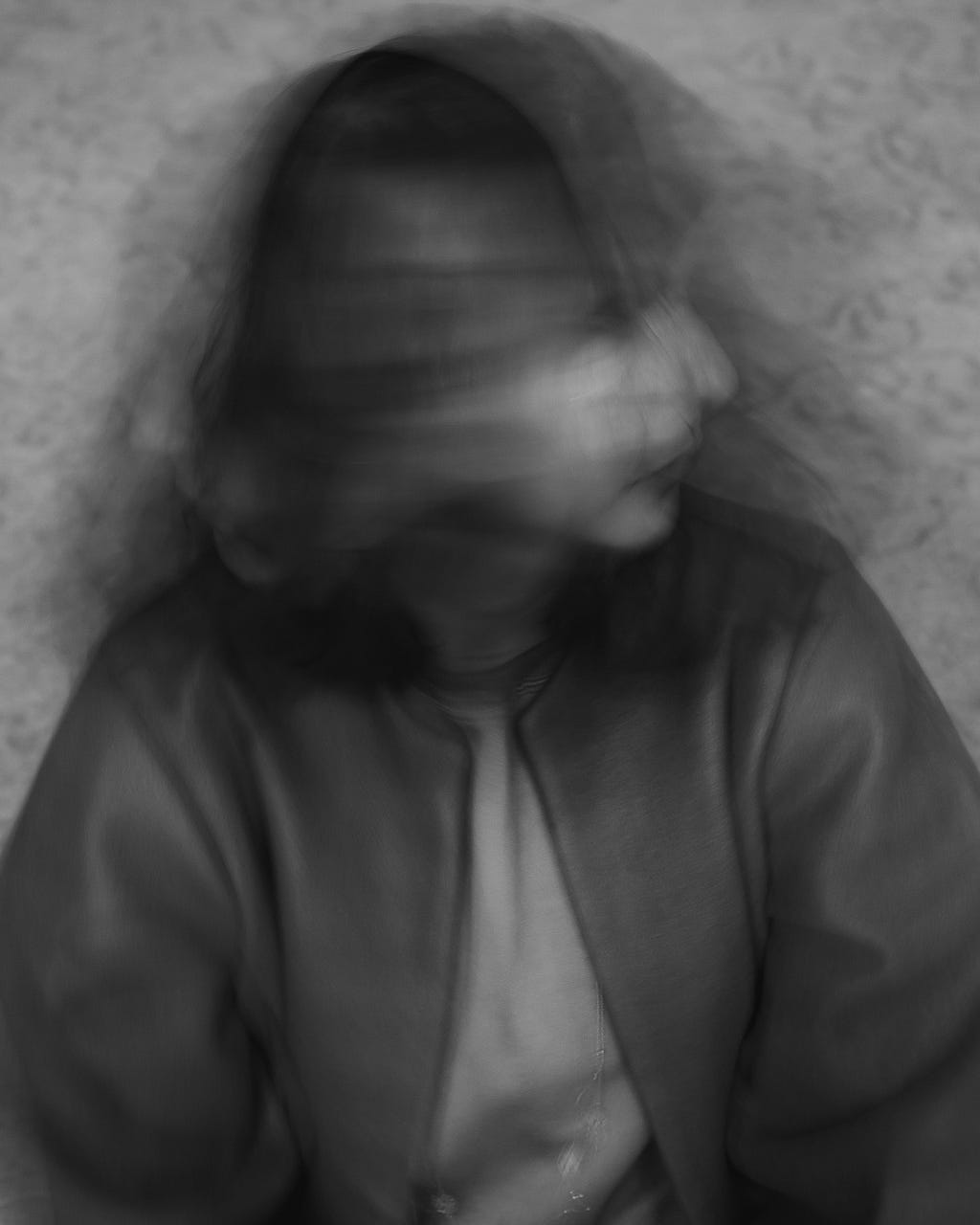 Seorang Perempuan menggeleng-geleng seolah-olah lelah dan stress. Foto berupa hitam putih.