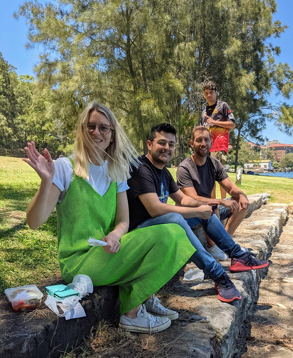 Three members of the Humanitix team plus Tyrese having lunch in a sunny park