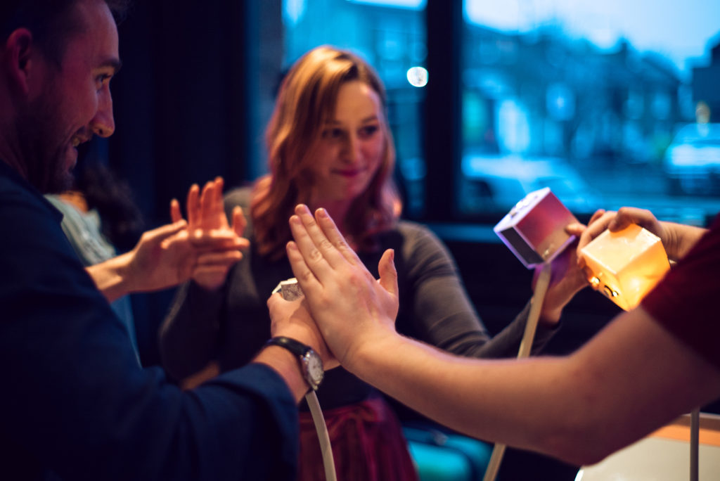 Three people touching hands in Bot Party.