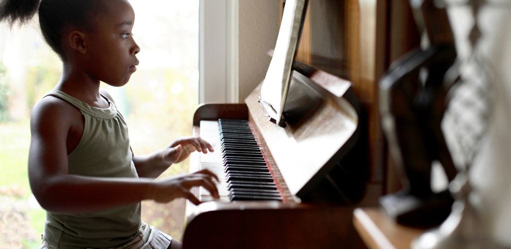 kid playing a piano