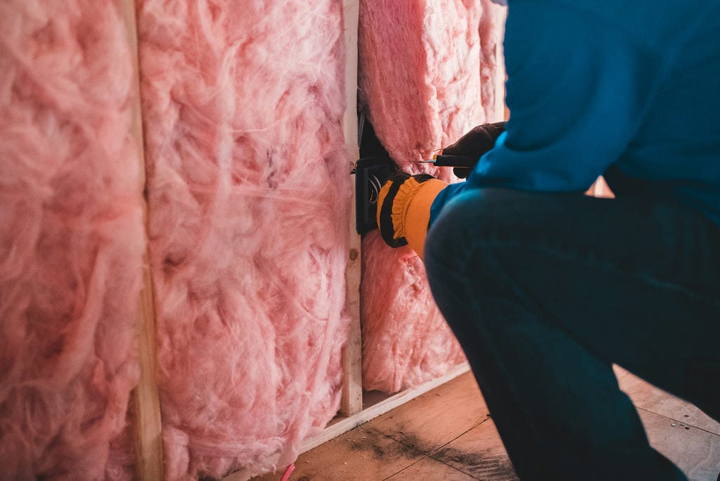 Image representing a worker fiberglass insulating a home