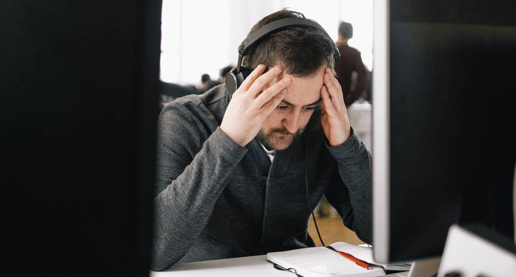 Frustrated entrepreneurs stuck at desk at work