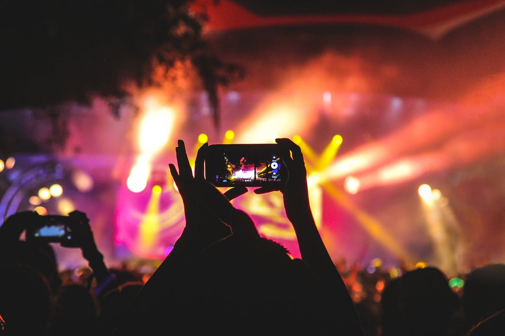 Attendees at a rock concert filming on their mobile phones