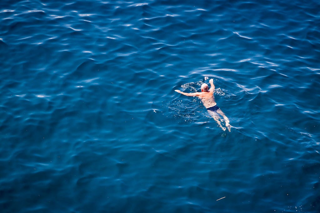 A person swimming in a lake, but doesn’t drink the water