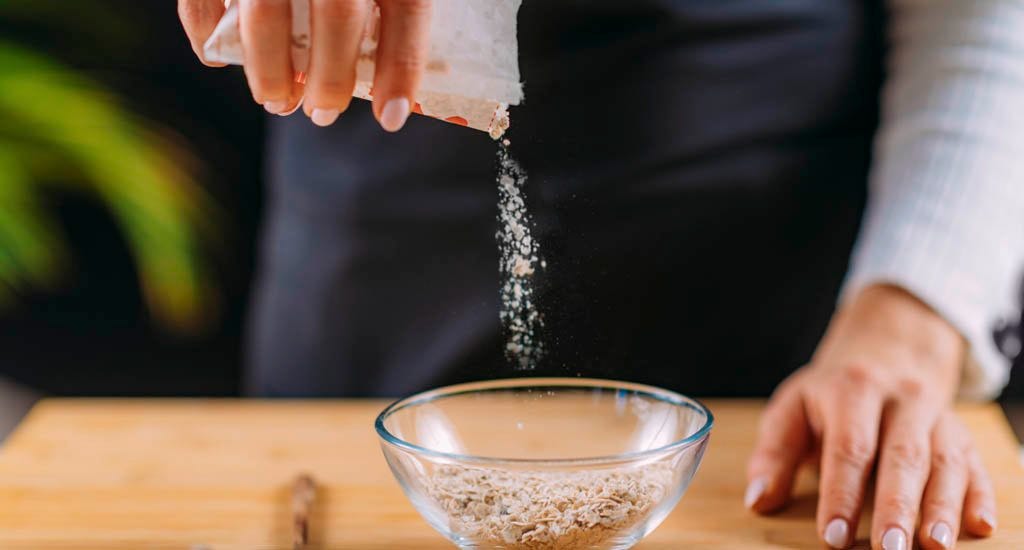 Entrepreneur pouring oats into bowl to make oatmeal