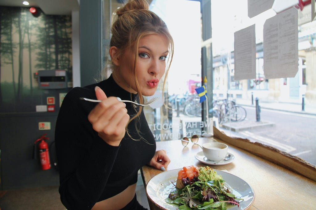 A girl eating an avocado toast.