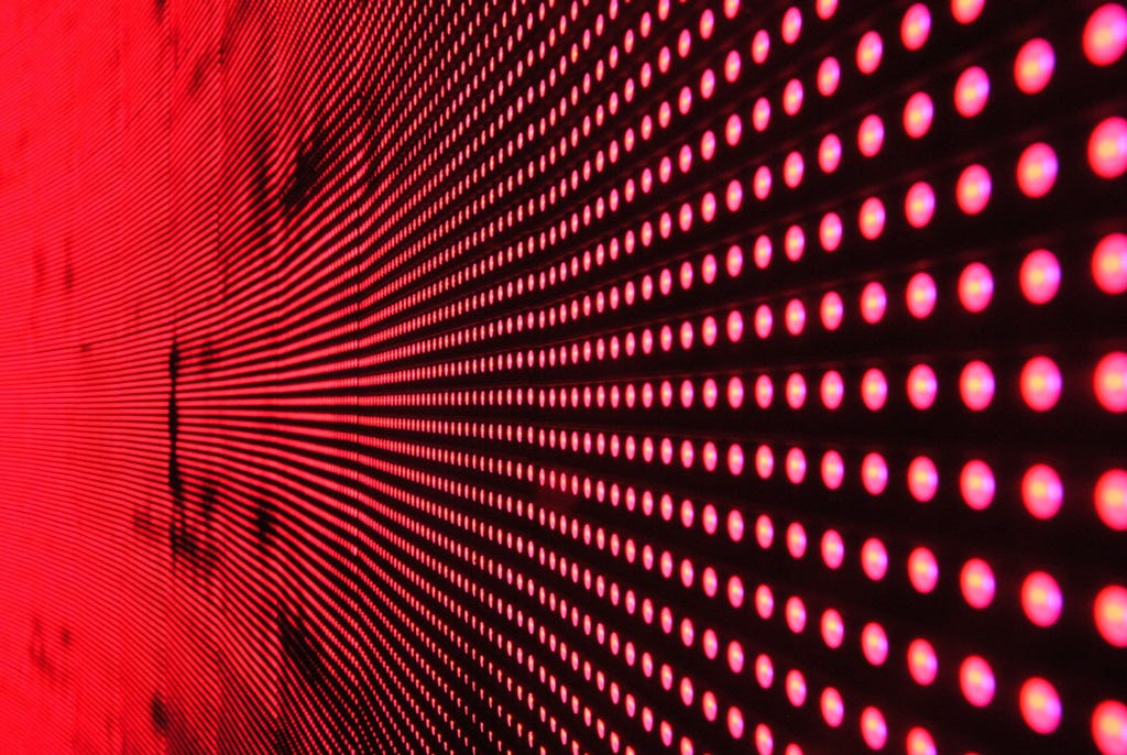 Close up shot of a wall of red LEDs that is curving into the distance