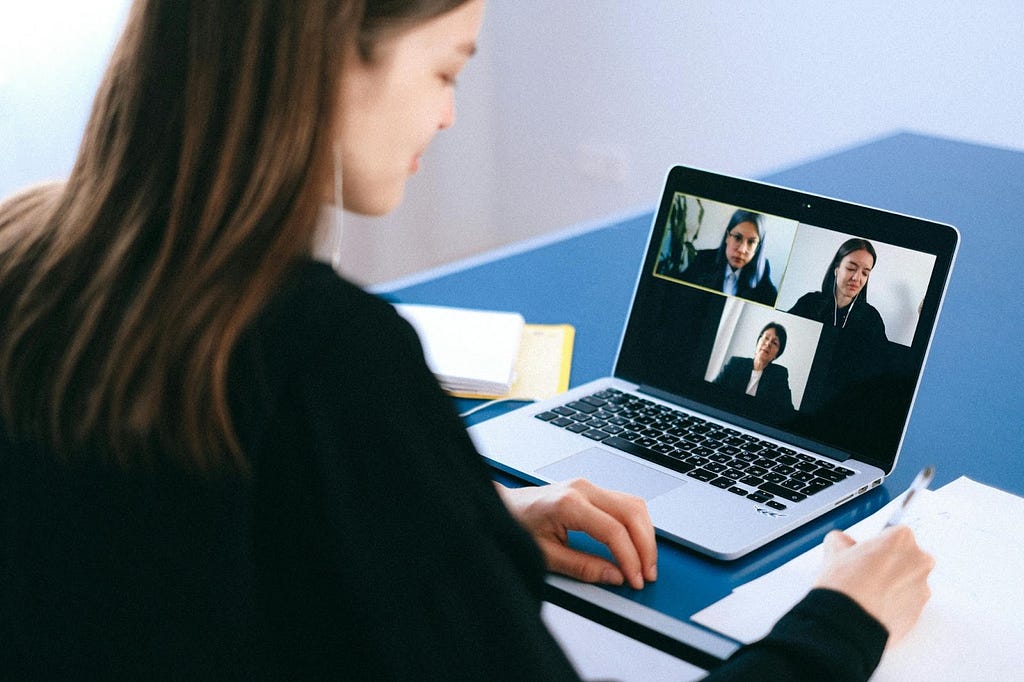 The image shows how people working remotely, having a virtual meeting to keep the team updated and organized with their work