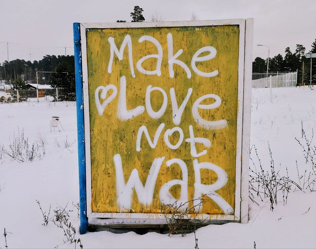 A sign in the snow that says ‘make love not war’