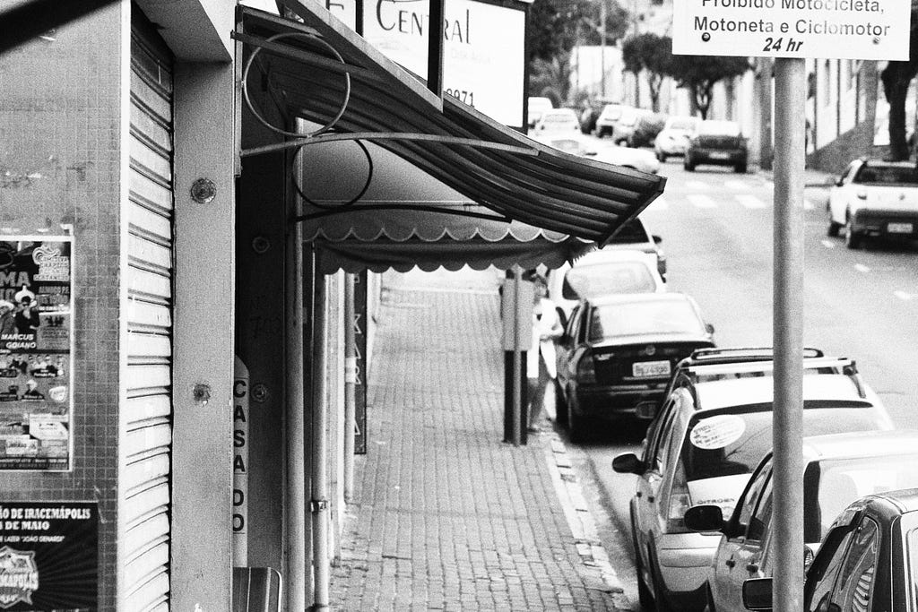 An black and white photo of a street with some cars.