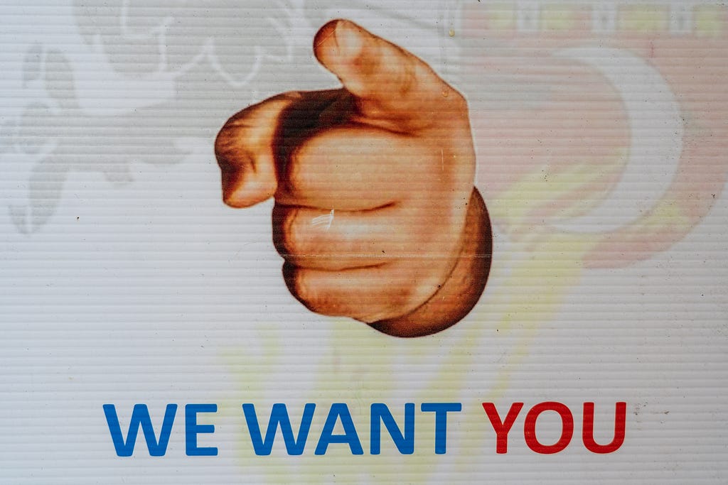 A poster showing a finger pointing at the viewer, and the text “we want you”