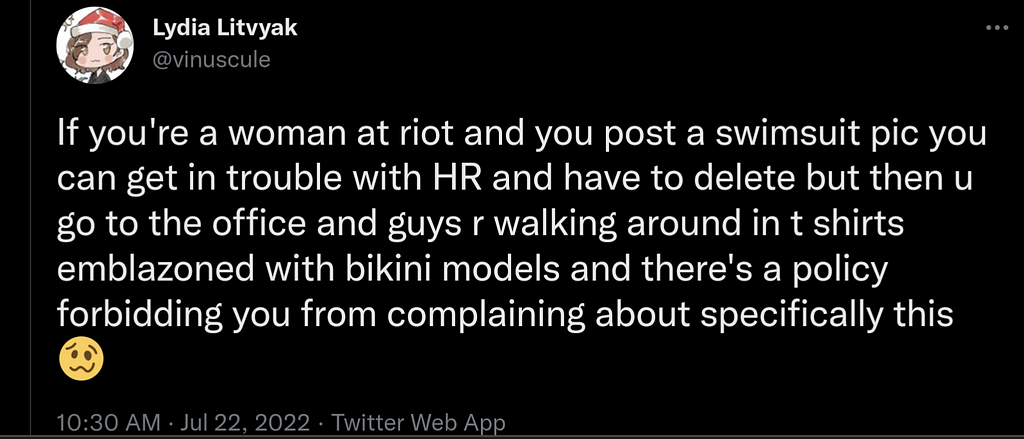 A screenshot of a tweet from Lydia Litvyak that reads, “If you’re a woman at riot and you post a swimsuit pic you can get in trouble with HR and have to delete but then u go to the office and guys r walking around in t shirts emblazoned with bikini models and there’s a policy forbidding you from complaining about specifically this 🥴”