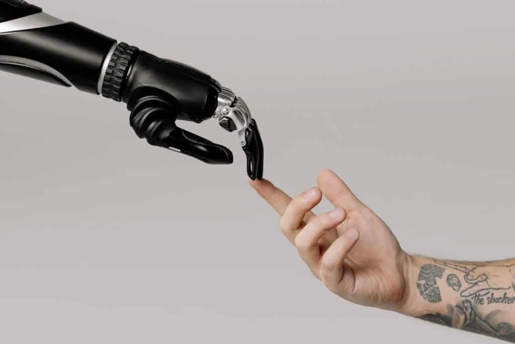 A robot hand reaching out and touching a finger on a human hand
