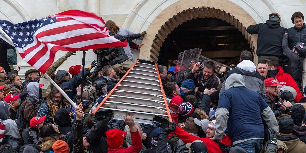 Rioters clash with police using big ladder trying to enter Capitol building through the front doors.