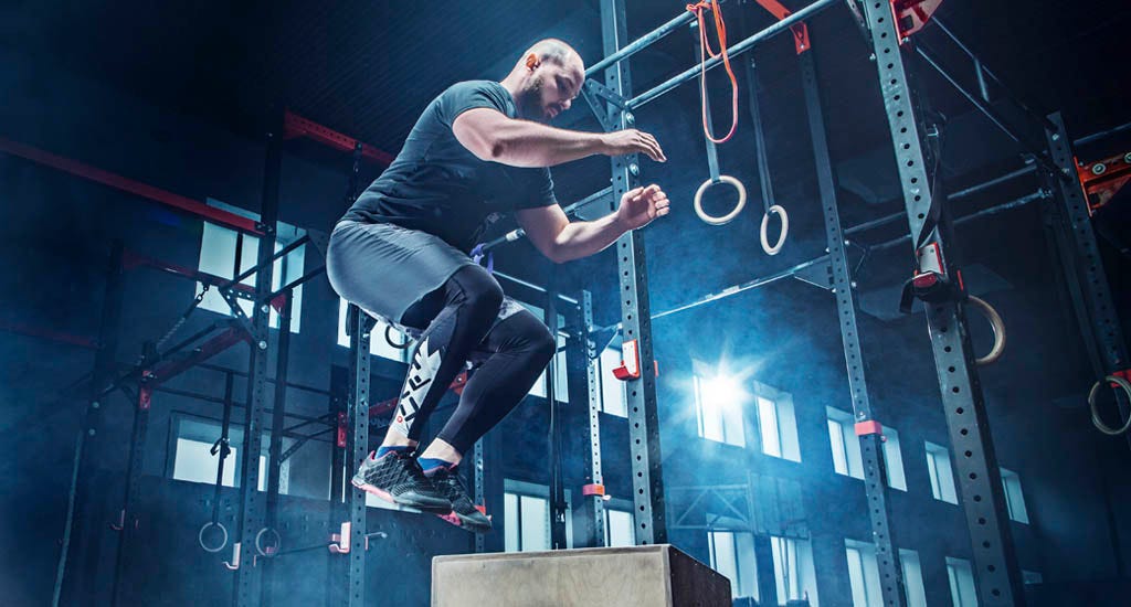 Man practicing plyometrics by jumping training in gym