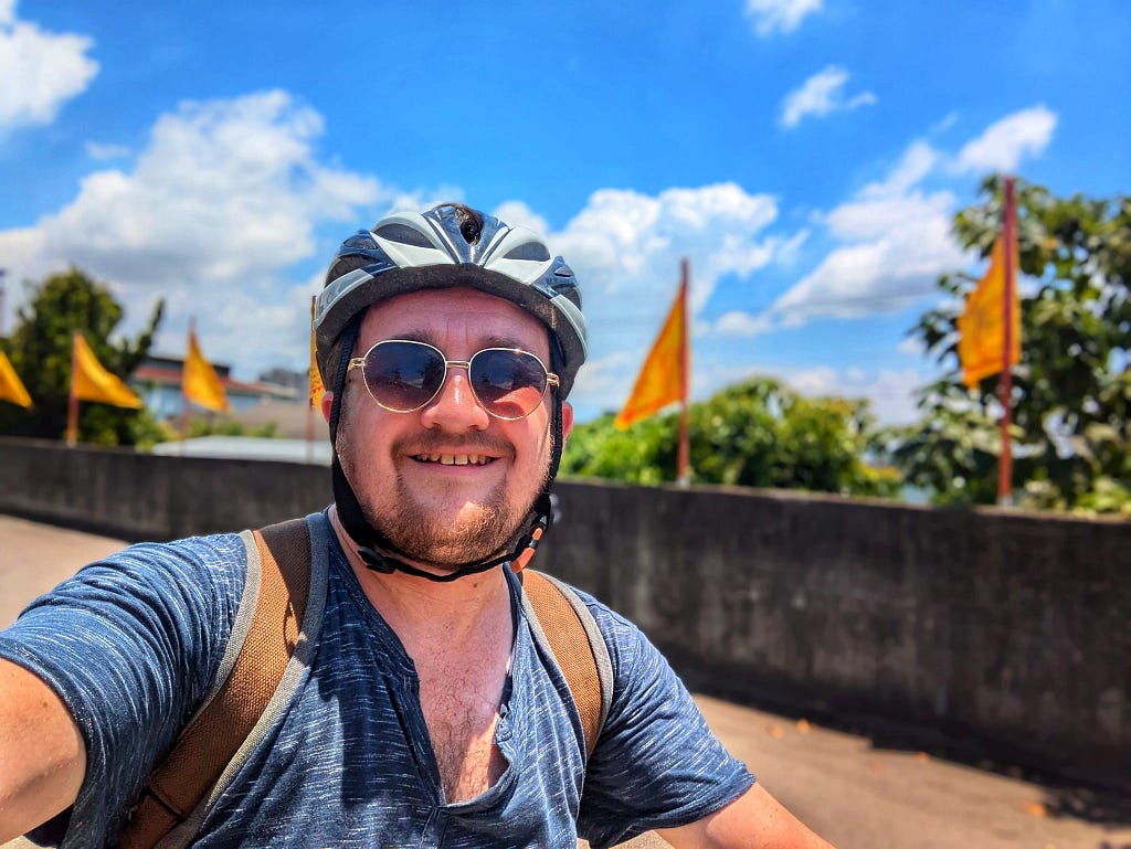 A picture of me on the bike with Buddhist flags behind me.