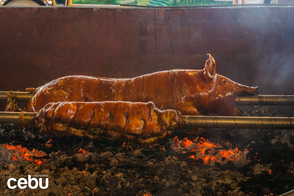 Lechon being roasted on an open grill
