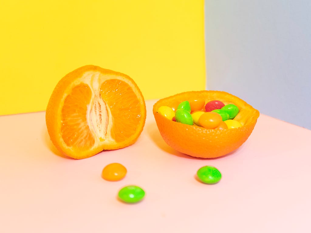 A cut open orange filled with candy