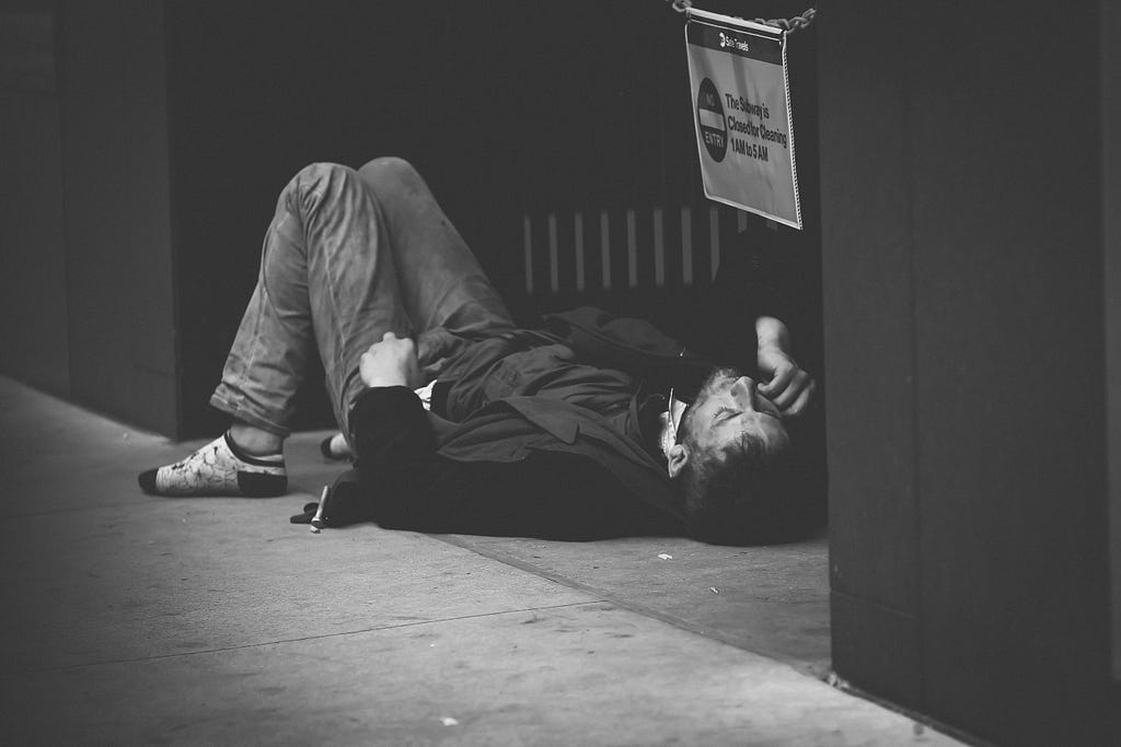 drug addict laying on street looking to be strung out