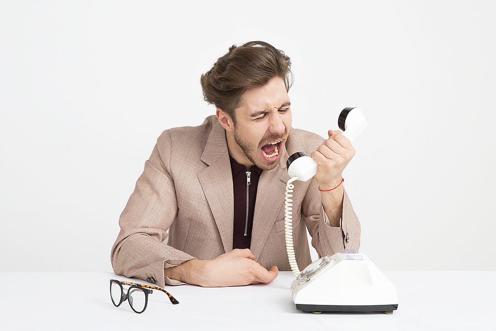 A man yelling into a telephone.