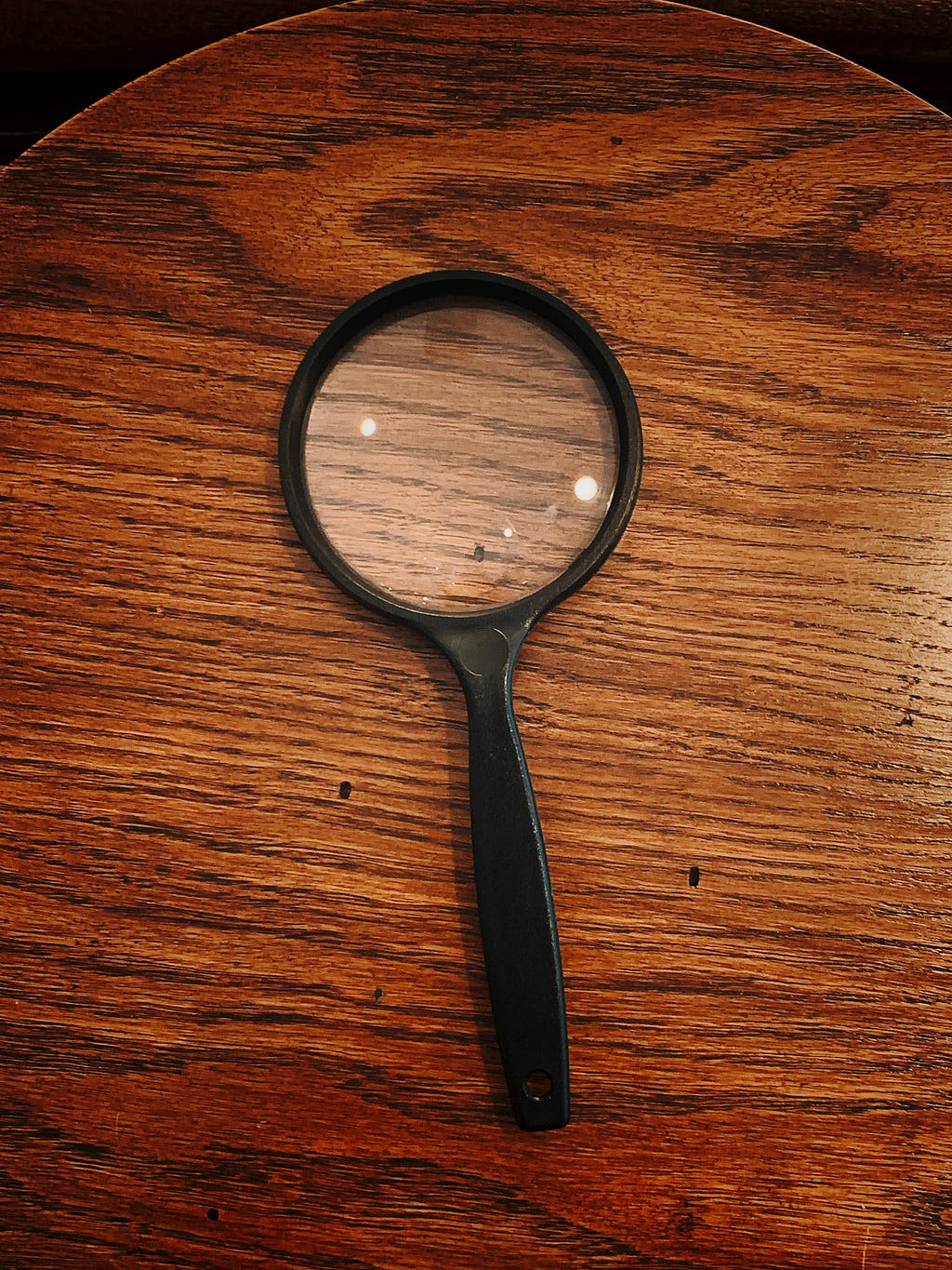A magnifying glass on a wooden table