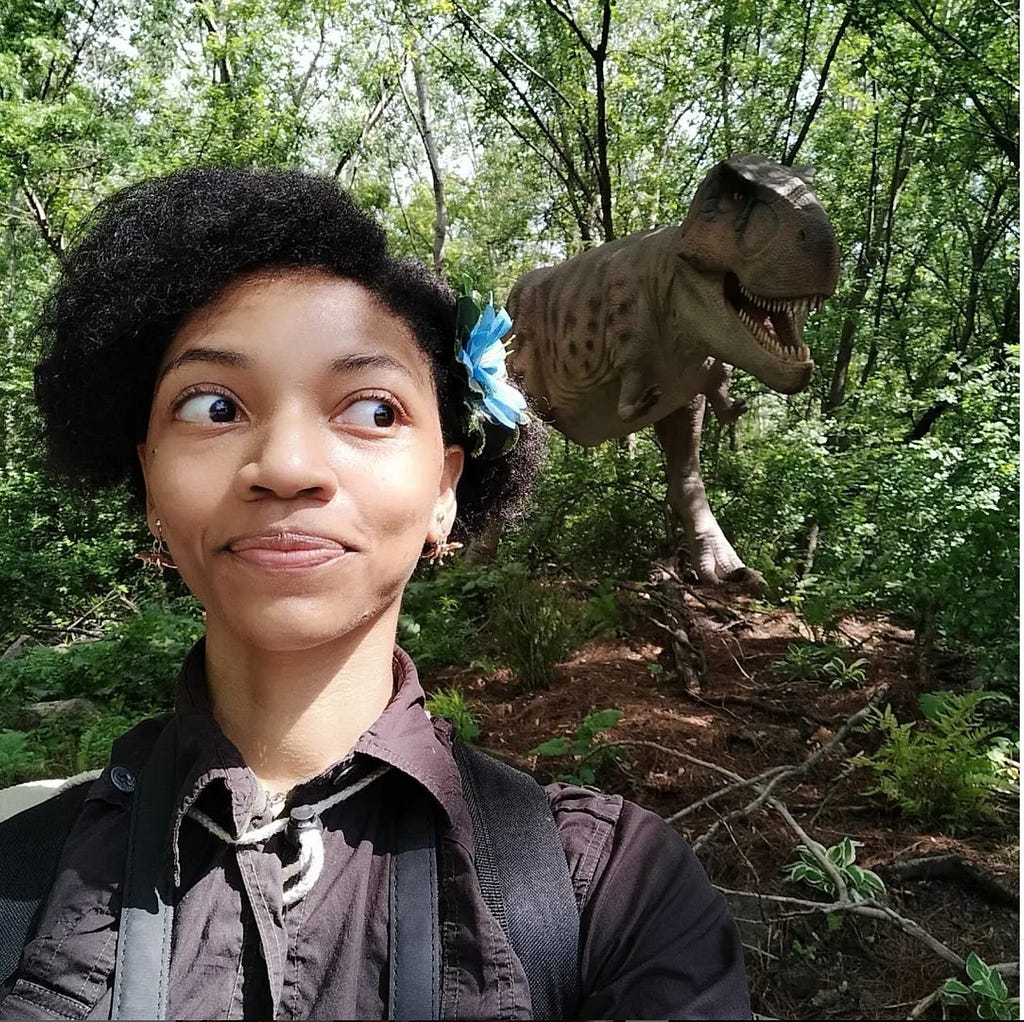 me looking back at a dinosaur at the Detroit Zoo’s Dinosauria exhibit with a look on my face that isn’t the bravest. God bless you!