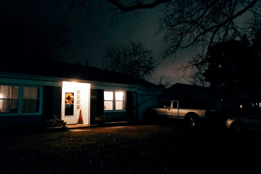underexposed photo of a suburban ranch home late at night