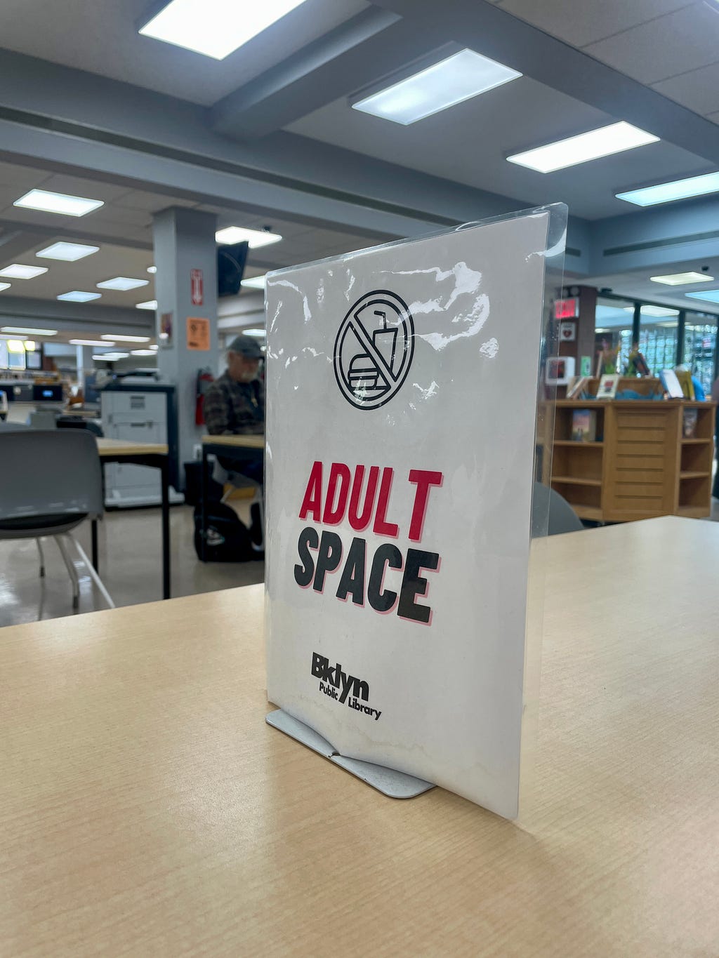 sign reading “adult space” on a table at the brooklyn library