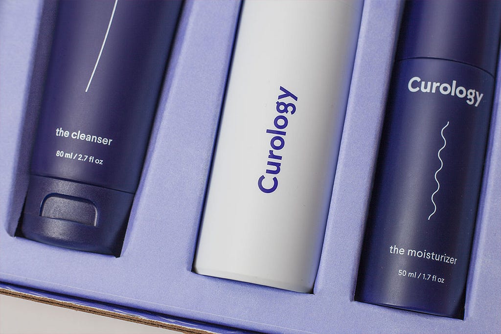 Close-up of the Curology skincare set: the cleanser, prescription superbottle, and moisturizer