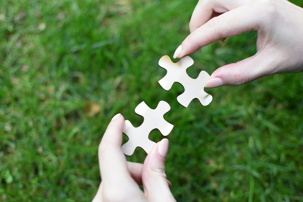 A person holding a piece of puzzle in their hands
