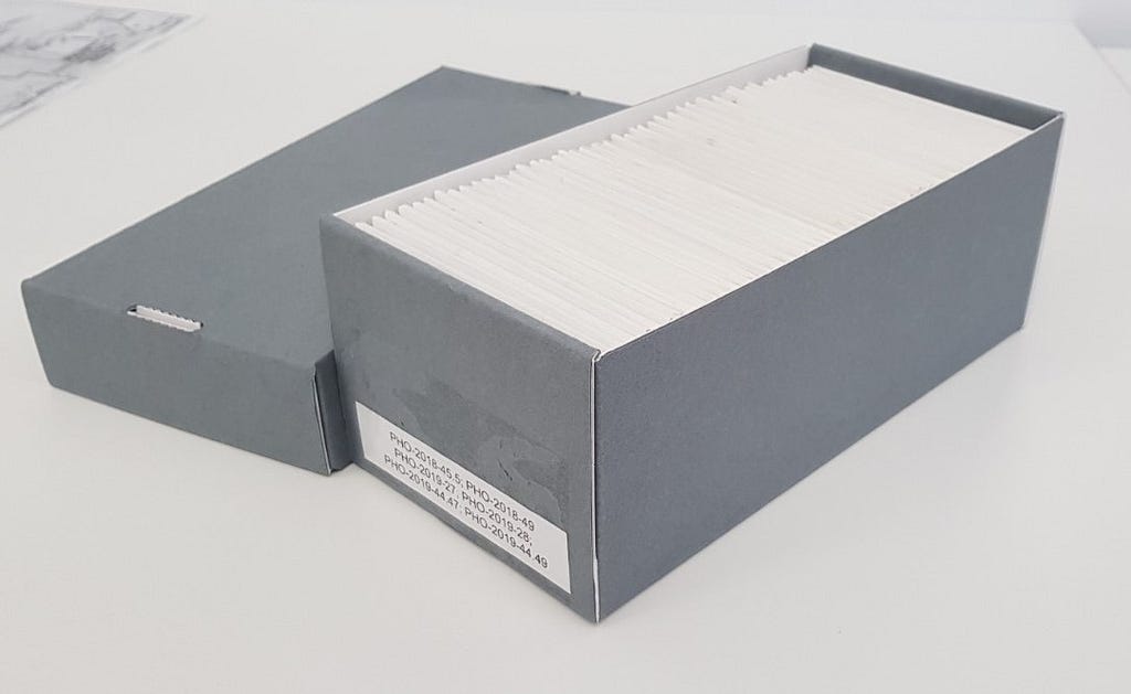 An archival box housing glass plate negatives in envelopes