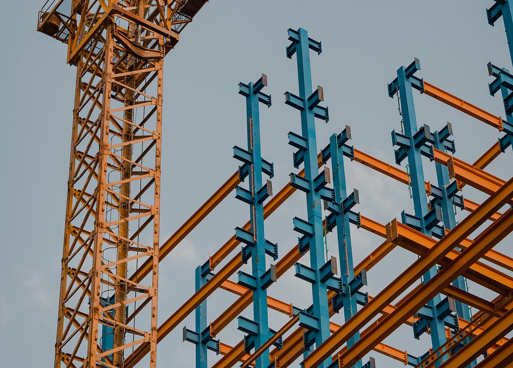 Crane and steel construction against sky