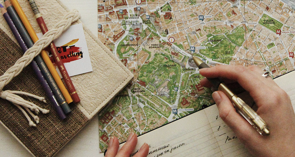 Photo of a person looking over a map and writing down notes