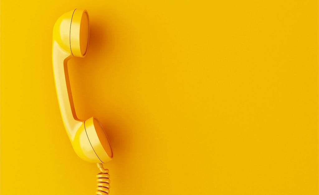 All in yellow: an oldscool telephone handset on a yellow background.