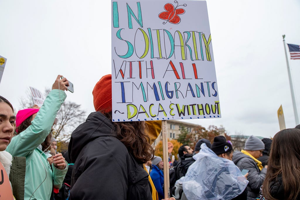 Picture of the Home is Here Walkout with a sign that reads: In solidarity with all Immigrants DACA and without