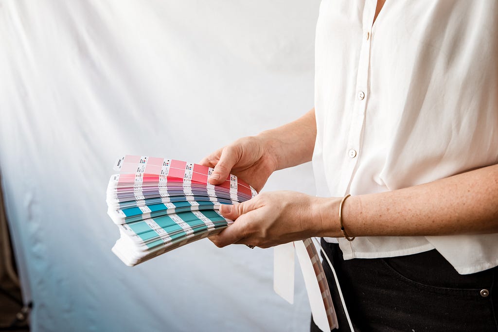 Woman holding Pantone color books.