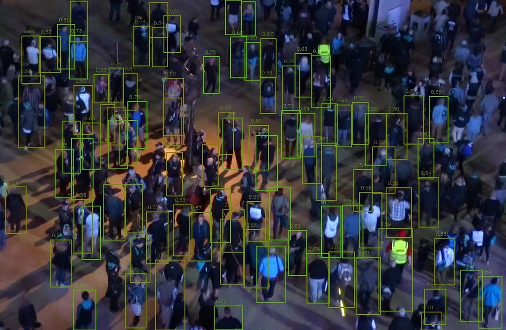 La photographie d’une foule en extérieur montrée précédemment. Les personnes ne sont pas toutes détectées, mais beaucoup plus le sont que dans la première photographie.