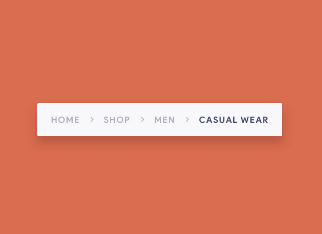 Stand-alone breadcrumb trail showing four visited links with an arrow pointing right in between each one. The links are “home”, “shop”, “men”, and “casual wear”. “Casual wear” is bolded to show current status.