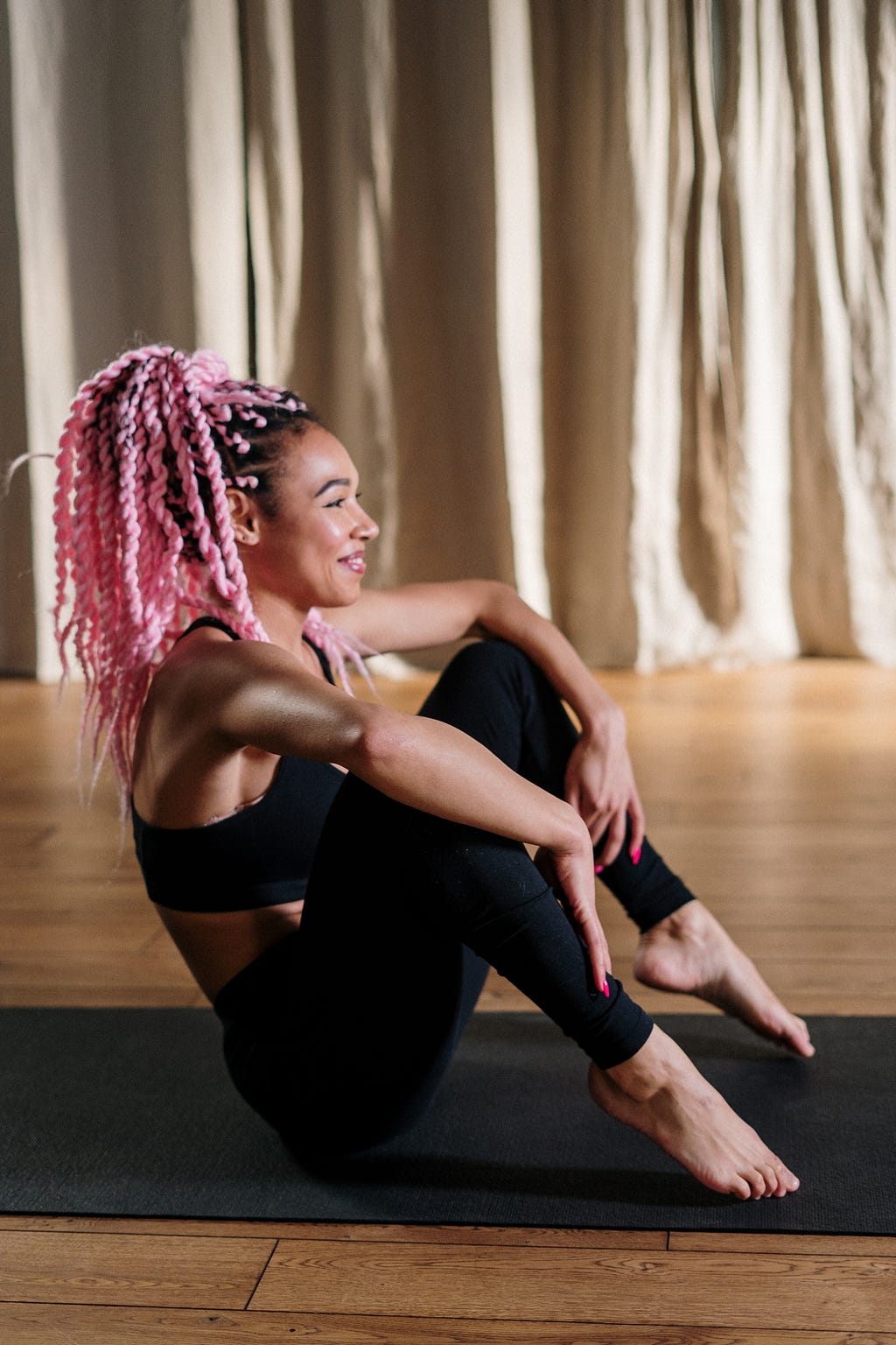 smiling woman sitting on a yoga mat <a href=”http://www.freepik.com">Designed by Freepik</a>