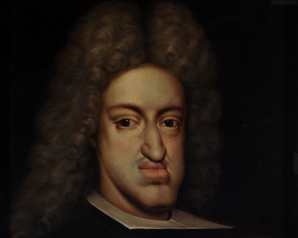 Close-up of a dark, classical oil portrait of an aristocratic man (Karl II., Spain) wearing a large curled wig and formal clothing, shown against a nearly black background.