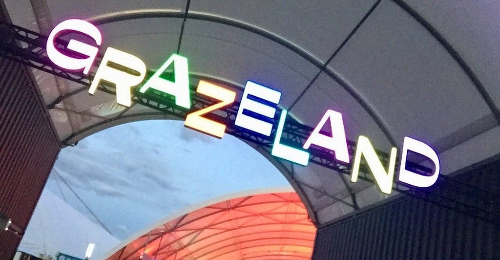 A neon sign with offset, multi-coloured lettering proclaims the entrance to Grazeland.