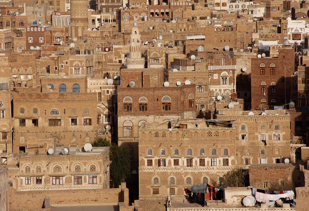 Photo of an aerial view of an urban cityscape featuring brown buildings in Yemen.